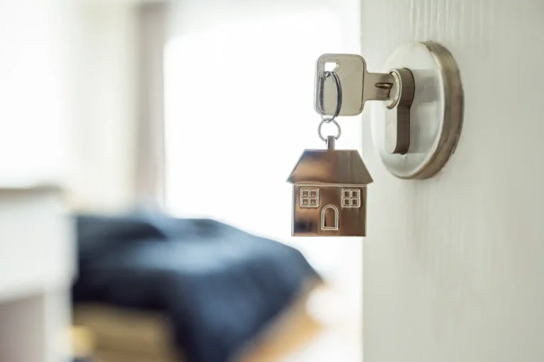 Llave en cerradura con figura de casa simbolizando el contrato de alquiler de vivienda y la figura del arrendador gran tenedor en la normativa vigente