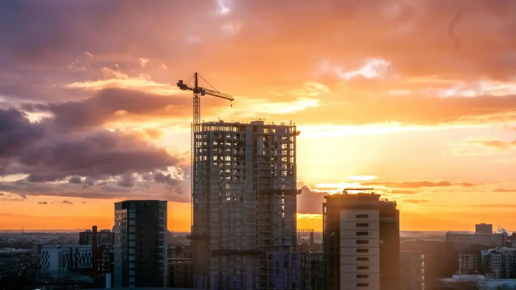Edificio en construcción con grúa al atardecer representando defectos de construcción en vivienda de obra nueva y posibles reclamaciones legales en Zaragoza