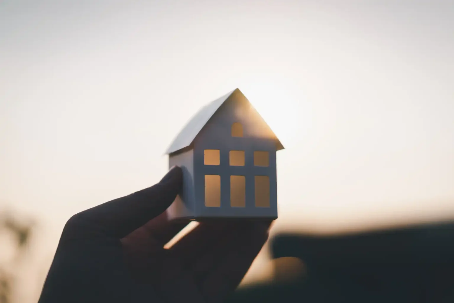 Casa en mano simbolizando la planificación de herencias y la organización de una empresa familiar inmobiliaria mediante sociedad patrimonial