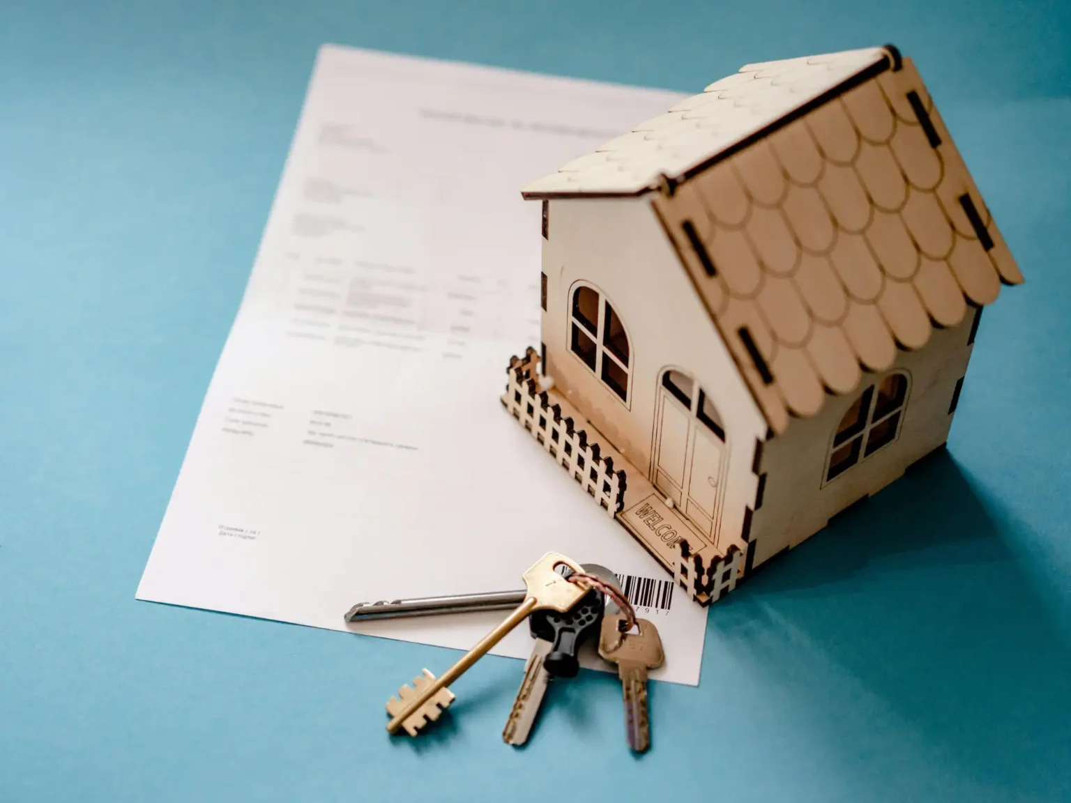Casa en maqueta con llaves sobre contrato representando la recuperación de arras tras la denegación de una hipoteca en compraventa de vivienda
