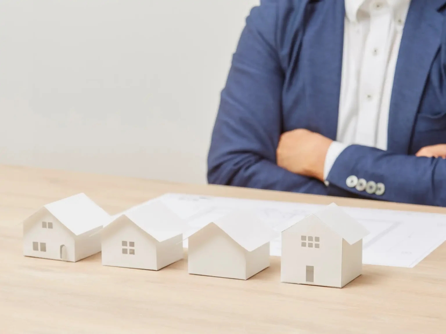 Maquetas de viviendas sobre mesa representando la gestión de rentas inmobiliarias a través de una sociedad patrimonial y su análisis fiscal