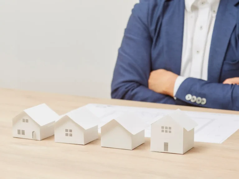 Maquetas de viviendas sobre mesa representando la gestión de rentas inmobiliarias a través de una sociedad patrimonial y su análisis fiscal